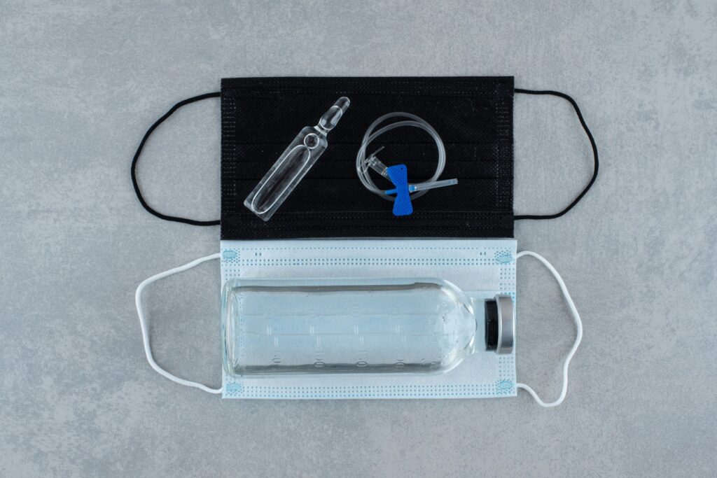 two-medical-masks-with-medical-ethanol-gray-background-high-quality-photo (1)